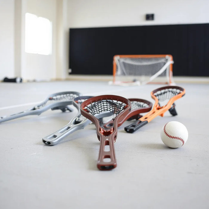 Assorted women’s lacrosse heads with different pockets arranged on a training surface